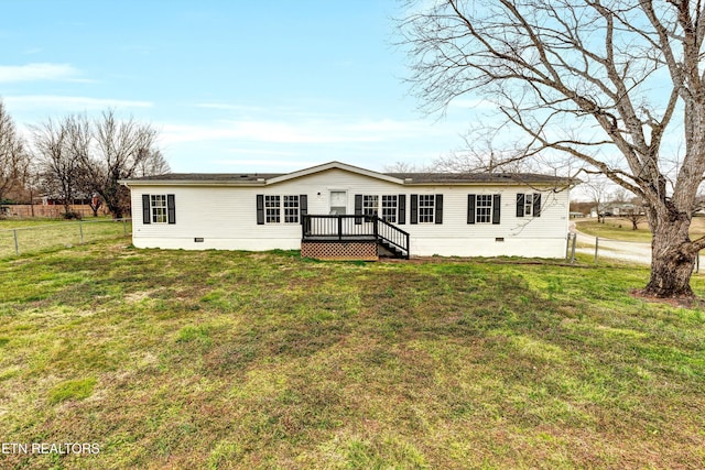 rear view of house with crawl space, a lawn, a deck, and fence