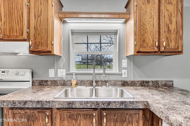 kitchen with white electric range oven, brown cabinetry, range hood, and a sink