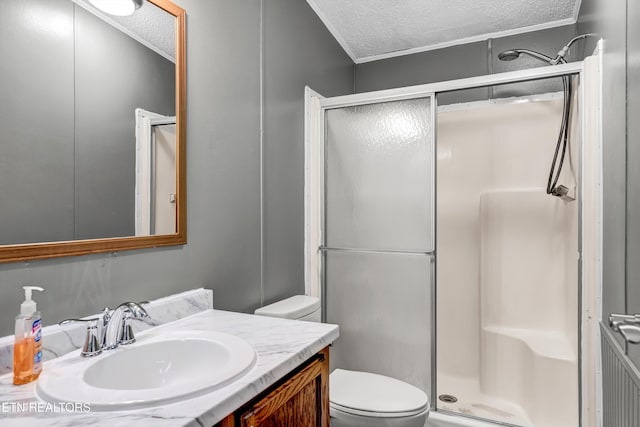 bathroom featuring vanity, toilet, a stall shower, and a textured ceiling