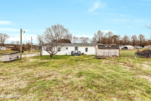 back of property featuring a lawn and fence