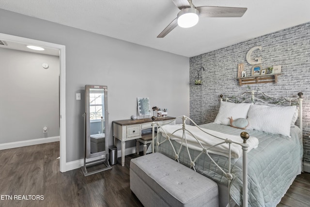 bedroom featuring wood finished floors, visible vents, baseboards, ceiling fan, and an accent wall