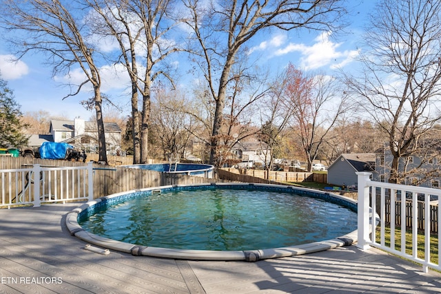 view of pool featuring a deck, a fenced in pool, and a fenced backyard