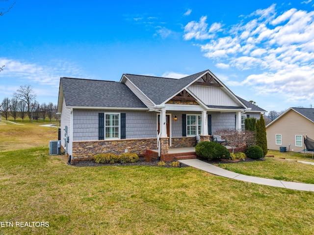 craftsman inspired home featuring a porch, central AC, a shingled roof, a front lawn, and stone siding