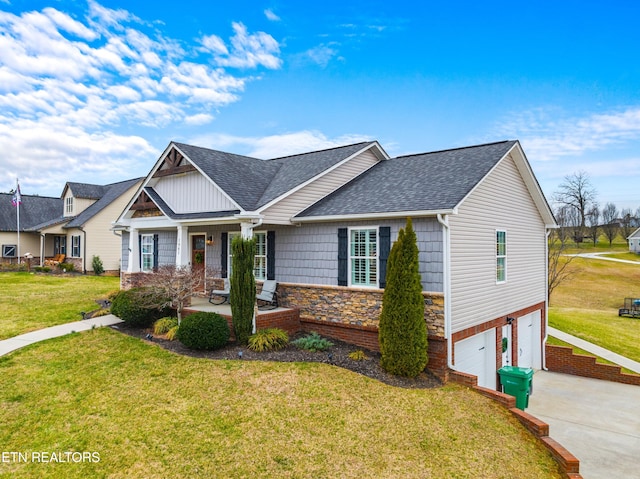 view of front facade featuring a front yard, a garage, stone siding, and roof with shingles