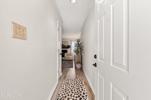 hall featuring light wood-style flooring and baseboards