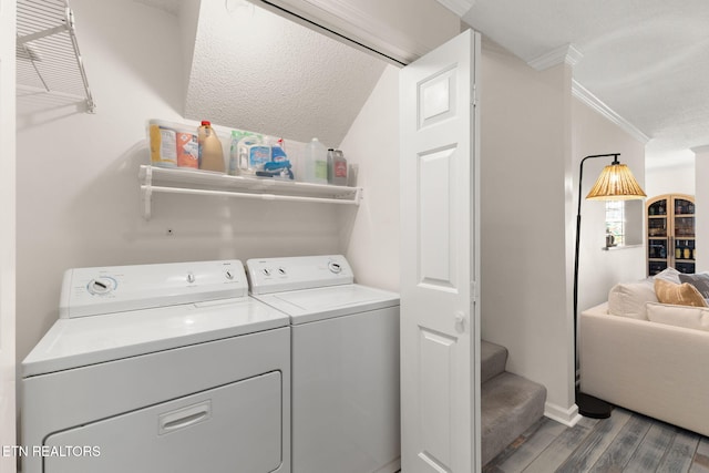 laundry area with a textured ceiling, wood finished floors, crown molding, laundry area, and washing machine and clothes dryer