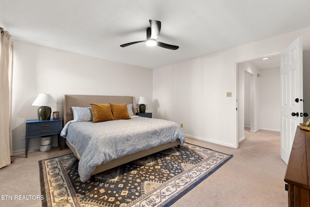 bedroom featuring a ceiling fan, baseboards, and light carpet