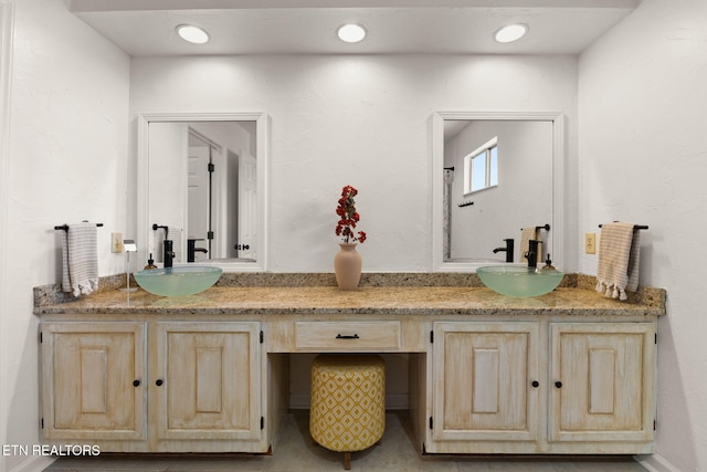 bathroom featuring a sink and double vanity