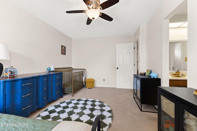 bedroom featuring a ceiling fan, light colored carpet, and baseboards