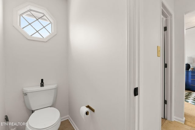 bathroom with toilet and baseboards