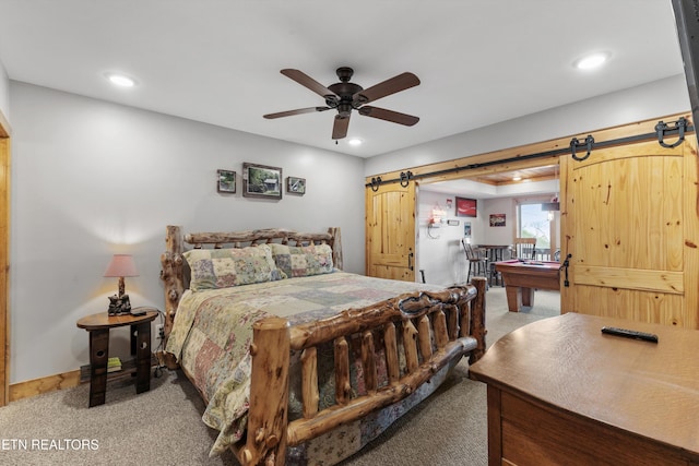 bedroom featuring recessed lighting, a barn door, baseboards, and light colored carpet