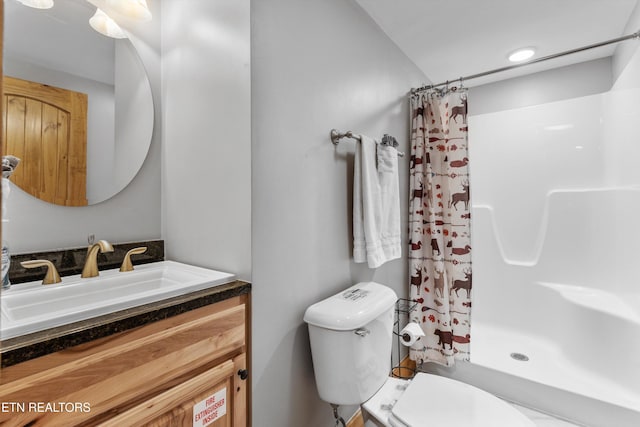 full bathroom with toilet, vanity, and a shower with curtain
