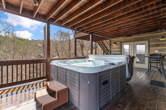 wooden terrace with stairs and a hot tub