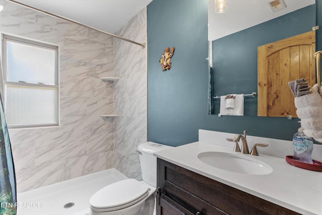 full bath featuring visible vents, tiled shower, toilet, and vanity