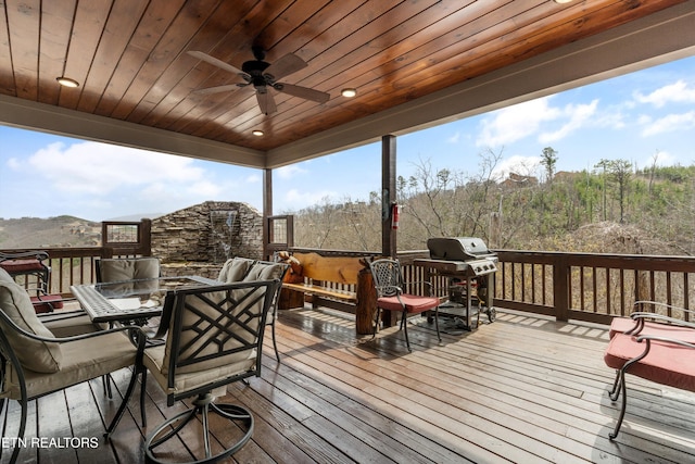 wooden deck with ceiling fan, outdoor dining area, and a grill