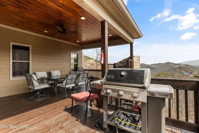 wooden deck featuring area for grilling, a mountain view, and outdoor dining space