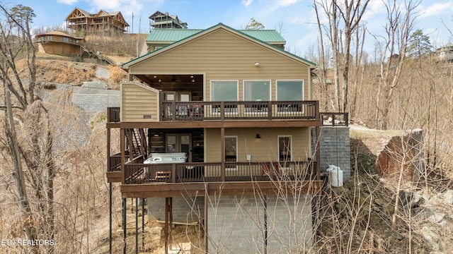 rear view of property with metal roof and a deck