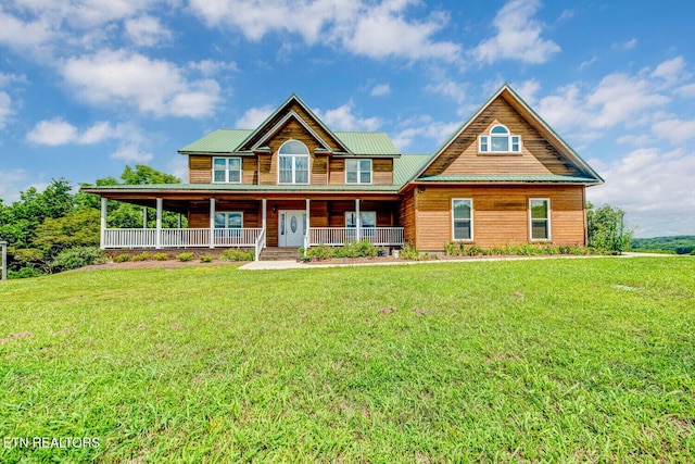 view of front of house featuring metal roof, covered porch, and a front yard