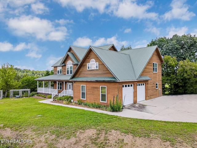 view of front of home featuring a front yard, covered porch, metal roof, a garage, and driveway