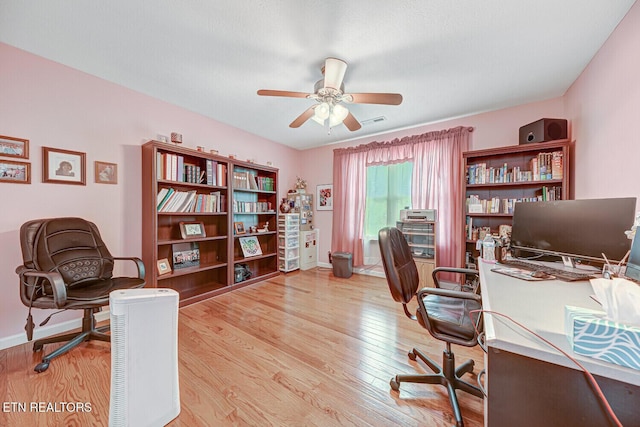 office space with visible vents, baseboards, a ceiling fan, and wood finished floors