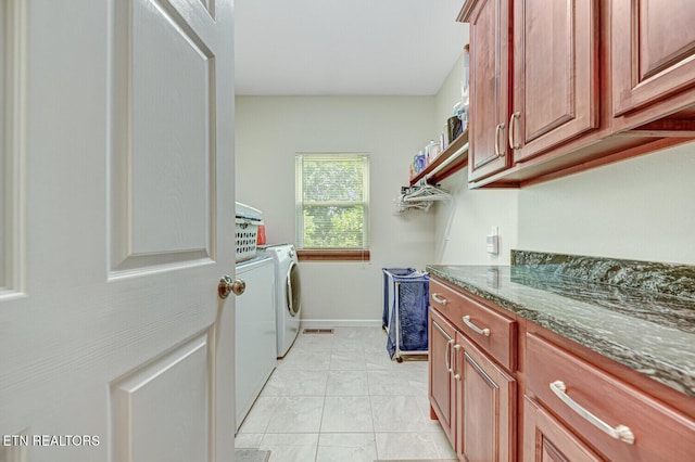 clothes washing area featuring washer and dryer, cabinet space, and baseboards