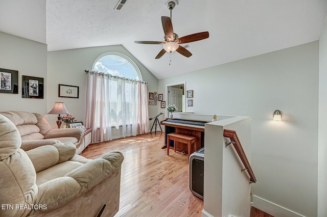 living room with visible vents, a textured ceiling, light wood-style floors, ceiling fan, and vaulted ceiling