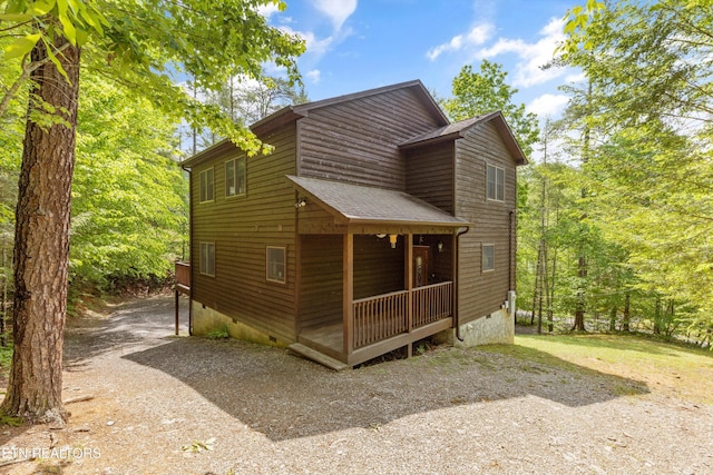 view of home's exterior featuring roof with shingles, covered porch, driveway, and crawl space