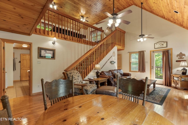 dining room featuring wooden ceiling, high vaulted ceiling, light wood-type flooring, and stairs