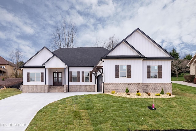 modern inspired farmhouse featuring driveway, brick siding, and a front lawn