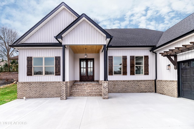 modern farmhouse style home with french doors, board and batten siding, and roof with shingles