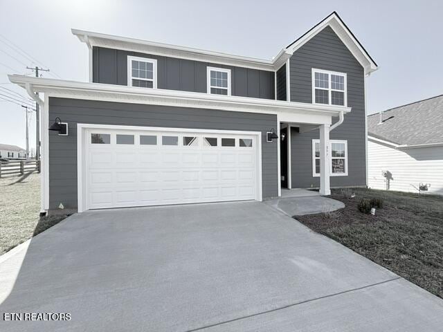 traditional-style house with an attached garage, board and batten siding, and driveway