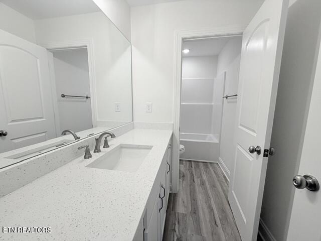 full bathroom with toilet, vanity, and wood finished floors