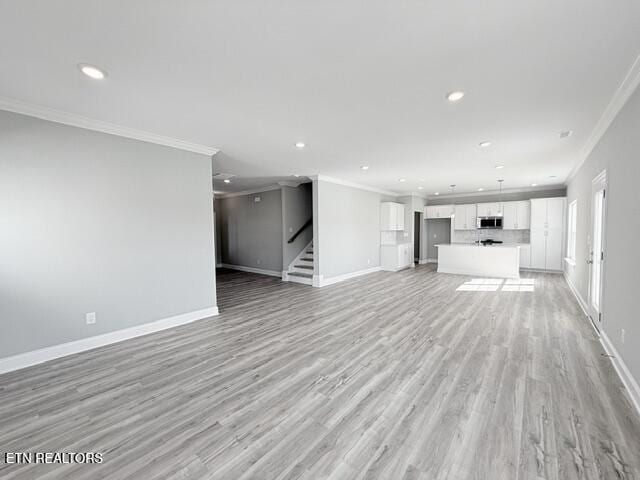 unfurnished living room with recessed lighting, stairs, baseboards, and ornamental molding