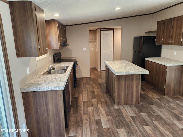 kitchen with a textured ceiling, dark wood-style flooring, electric range oven, and light countertops