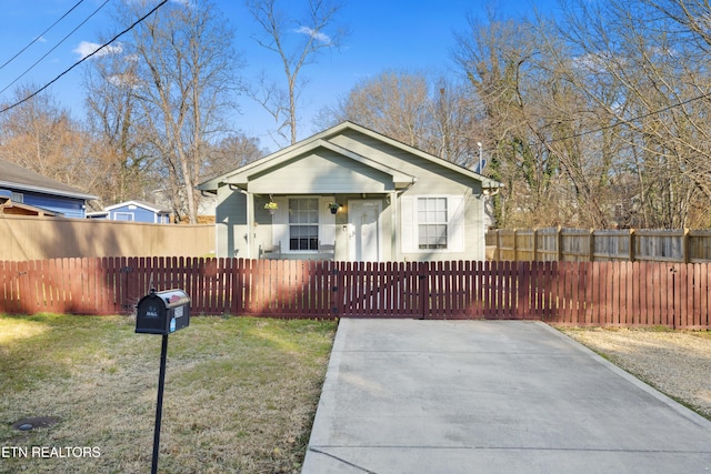 bungalow-style house with a front lawn and a fenced front yard