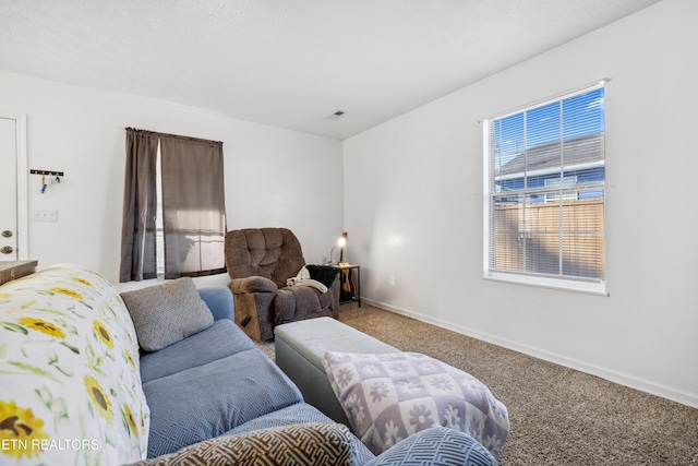 living area with carpet flooring, visible vents, and baseboards