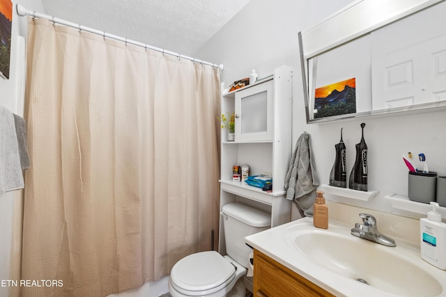 full bath featuring vanity, a shower with shower curtain, toilet, and a textured ceiling