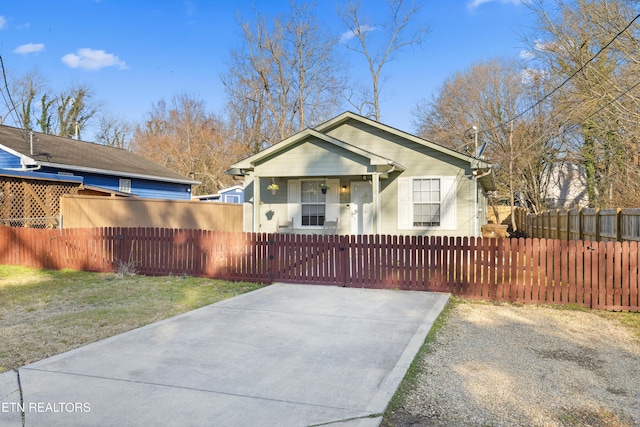 bungalow-style home with a fenced front yard, a front lawn, and a gate