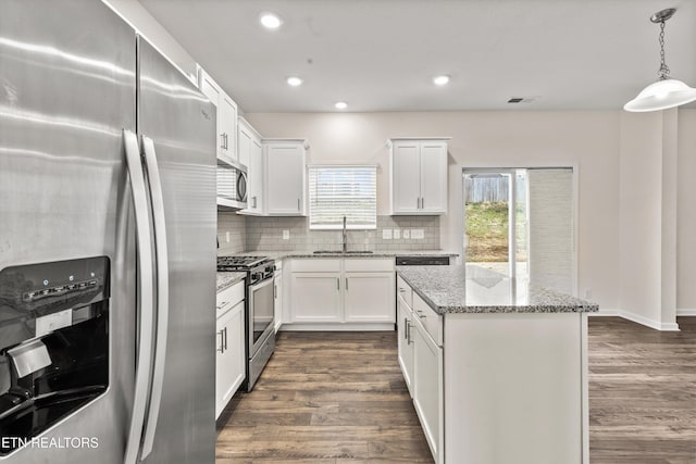 kitchen featuring tasteful backsplash, dark wood-style flooring, appliances with stainless steel finishes, and a sink