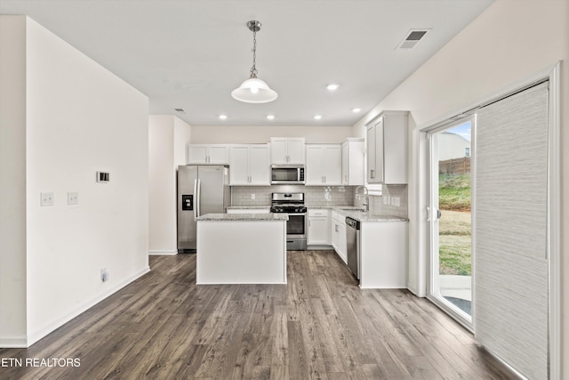 kitchen featuring dark wood-style flooring, a sink, decorative backsplash, appliances with stainless steel finishes, and a wealth of natural light