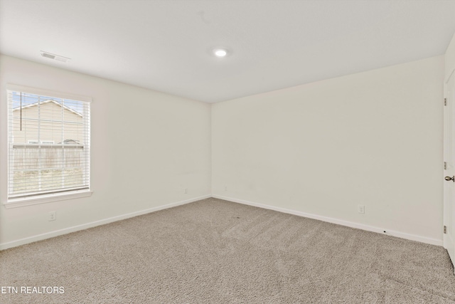 carpeted spare room with baseboards and visible vents