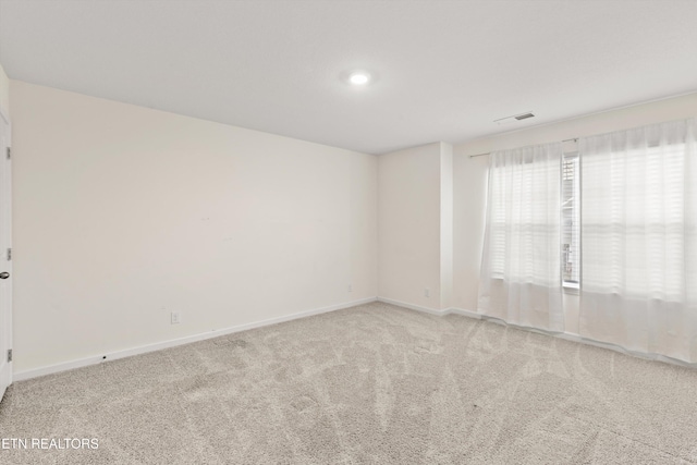 spare room featuring visible vents, baseboards, and carpet