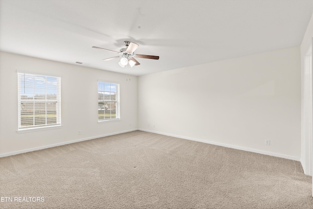 empty room featuring baseboards and light carpet