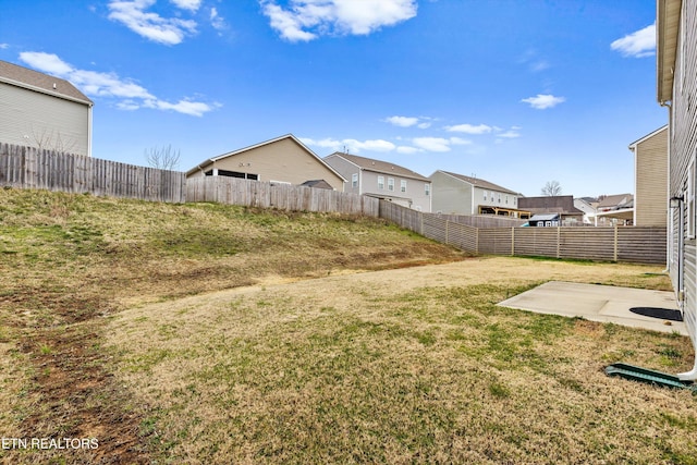 view of yard featuring a patio, a fenced backyard, and a residential view