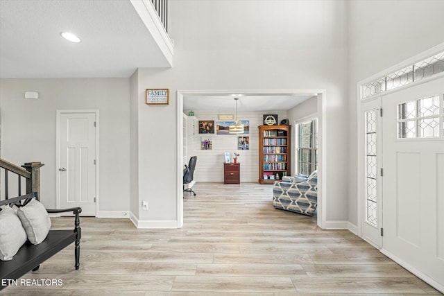 entrance foyer featuring baseboards, light wood-style floors, and stairs