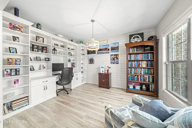 home office with light wood-style flooring and an inviting chandelier