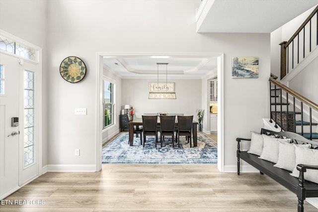 foyer featuring stairway, plenty of natural light, light wood-style flooring, and ornamental molding