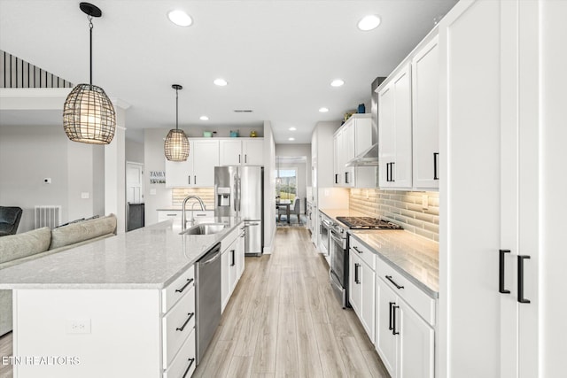 kitchen with recessed lighting, a sink, stainless steel appliances, white cabinets, and light wood-type flooring