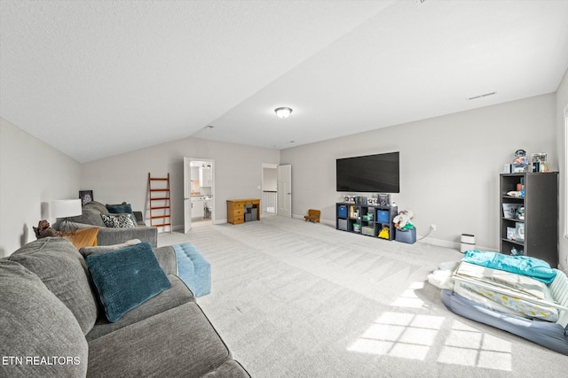 carpeted living room featuring lofted ceiling and baseboards