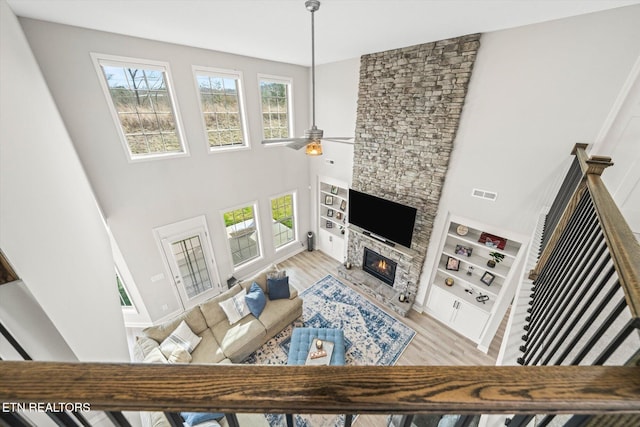 living room with a fireplace, visible vents, light wood finished floors, and a healthy amount of sunlight